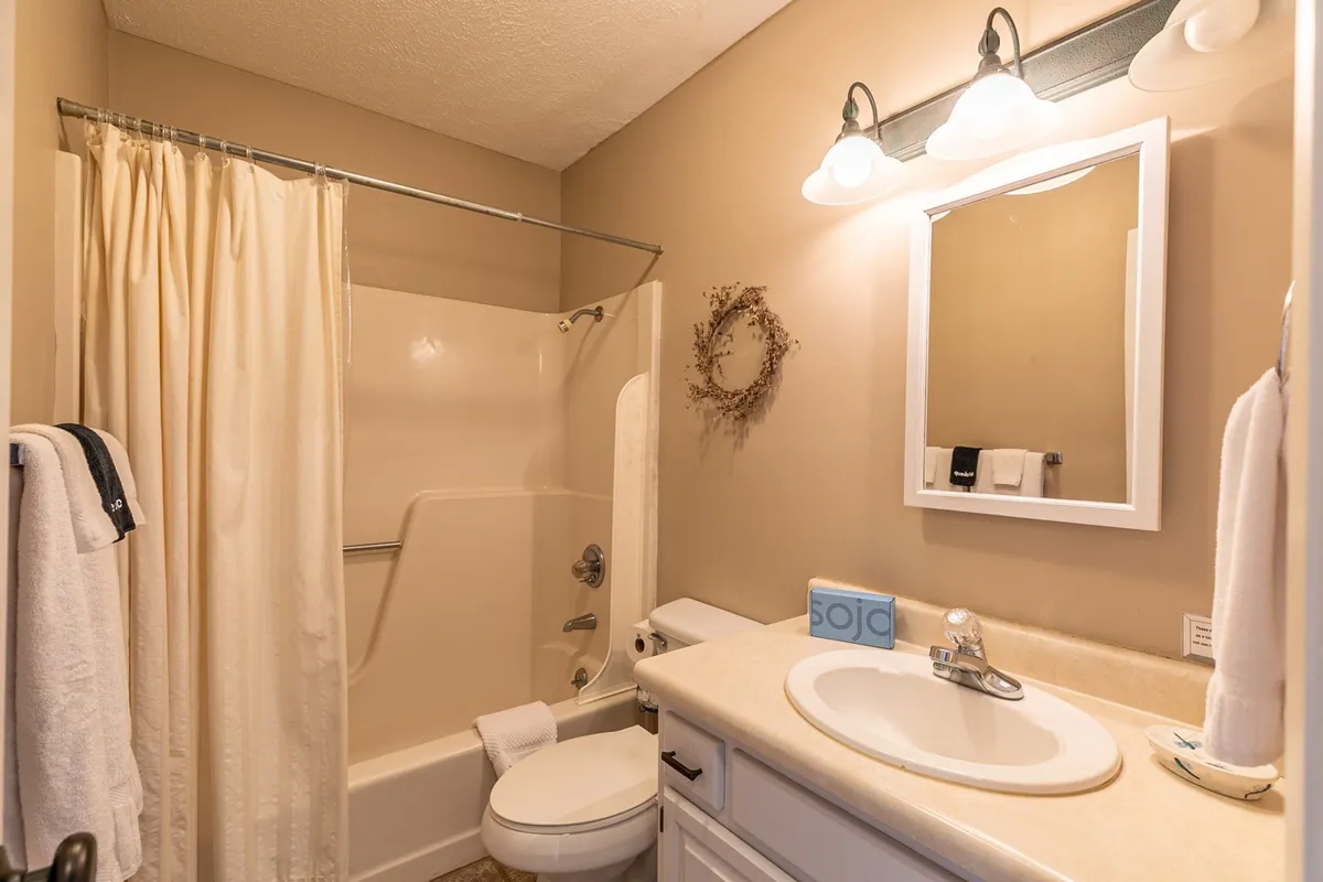 A modern bathroom featuring a spacious bathtub, elegant sink, large mirror, and soft lighting. The tranquil environment invites relaxation and self-care, with clean lines and a calming ambiance.